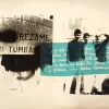 Serigrafía de Juan Castillo compuesta como un collage en tonos blanco y negro con una franja horizontal azul. A la izquierda aparece la frase “Reza me mi tumba” sobre una imagen oscurecida de un rostro parcialmente cubierto; a la derecha se ven tres figuras masculinas en una fotografía de alto contraste. Sobre la franja azul se superpone un texto manuscrito en blanco.