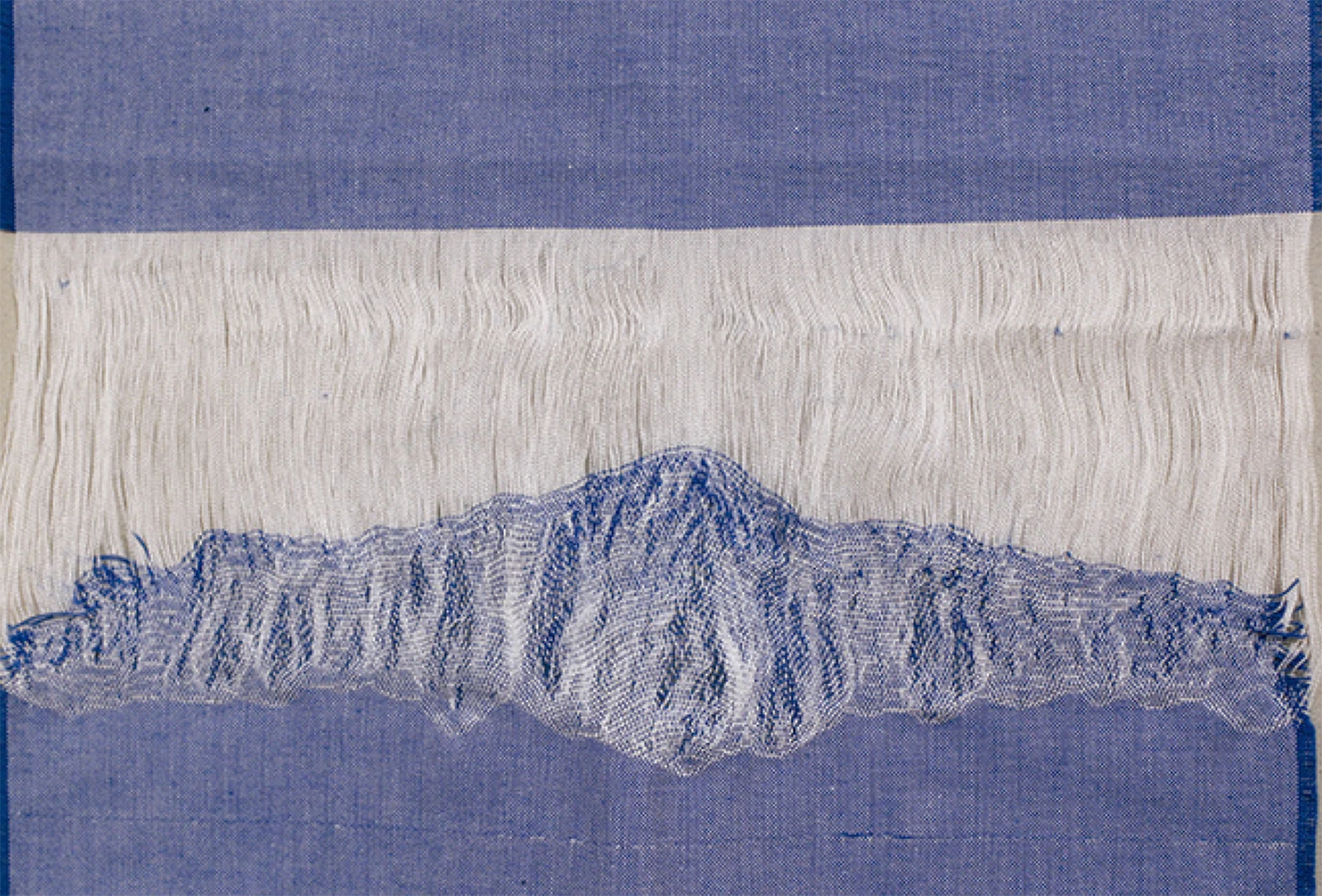 Detalle de obra textil de Macarena Cortés con fragmento de tela de algodón deshebrada en tonos azules y blancos que evoca una montaña nevada. 60 x 43 cm, pieza única, 2025.