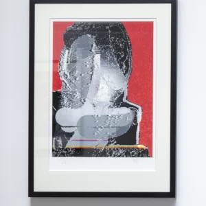Grabado digital de Ricardo Yrarrázaval que muestra un rostro fragmentado y superpuesto en tonos grises sobre fondo rojo intenso, con textura digital y efecto de distorsión, presentado en paspartú blanco y marco negro.